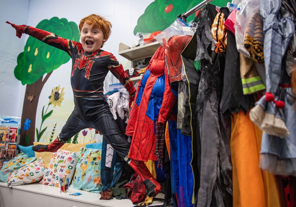 Myles Fidler, 6, of Oxford shows off his Spiderman costume by jumping off a small ledge at the costume closet display at the Oxford Public Library in Oxford, Iowa on Wednesday, October 8, 2025. This is the first year the city of Oxford is hosting a costume closet. The closet is a collection of gently used and new halloween costumes that are available for children for free. Monday through Thursday the costume closet is located at City Hall and Friday through Saturday the costumes are displayed at the library, with the exception of library events. (Savannah Blake/The Gazette)
