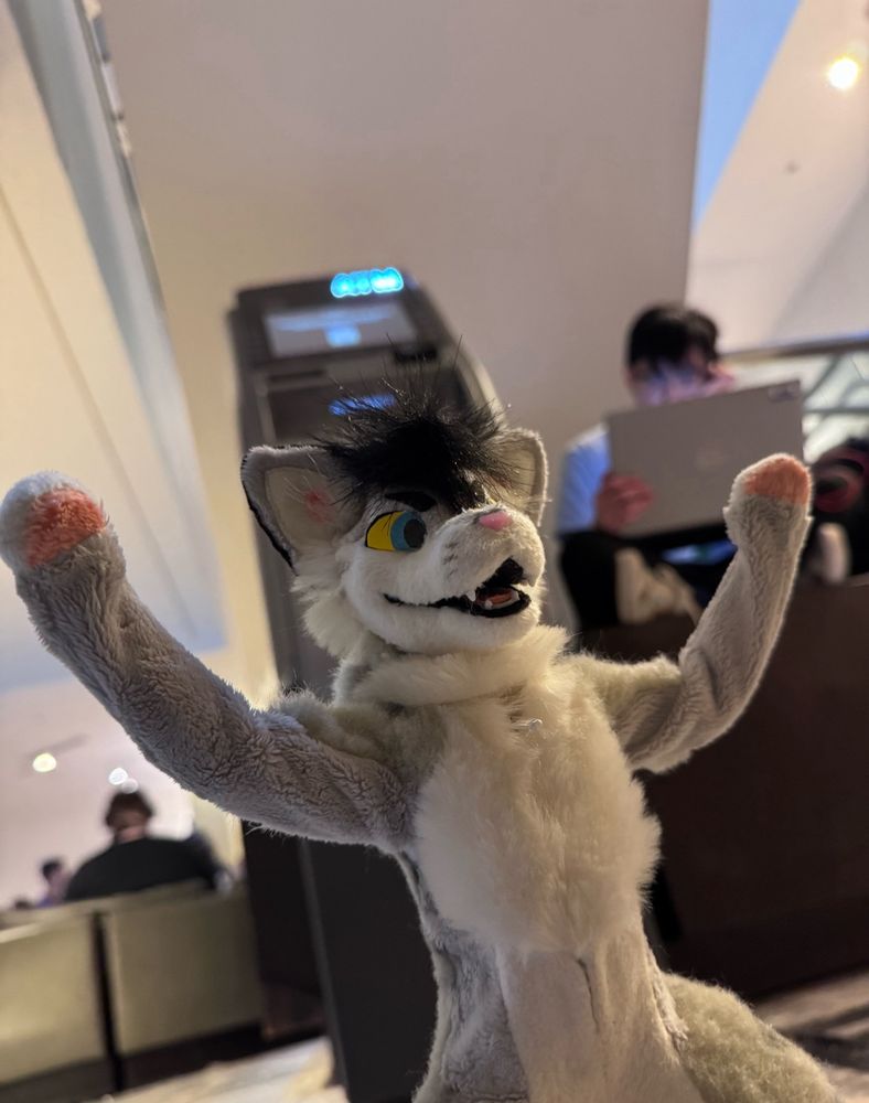 a photo of kaz's little homonculus gremlin in front of an atm