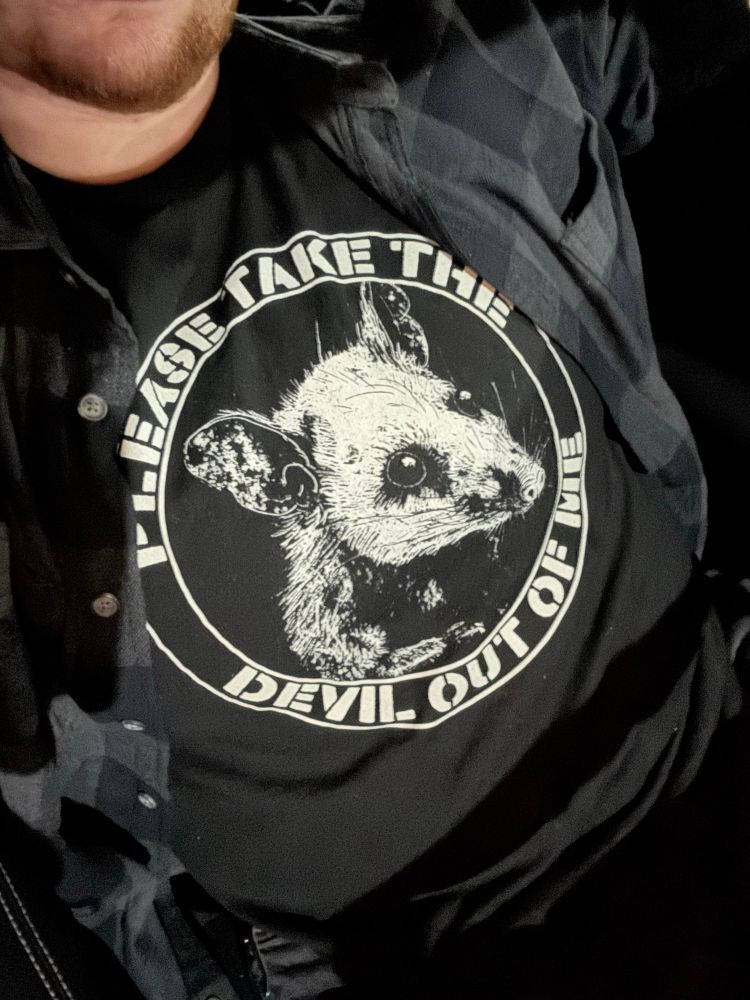 black t shirt with white design that says “PLEASE TAKE THE DEVIL OUT OF ME” with a picture of a possum