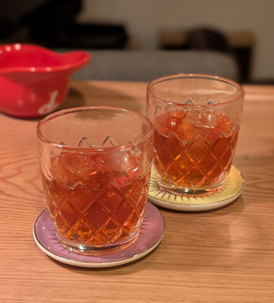 Two brown cocktails in lowball glasses 