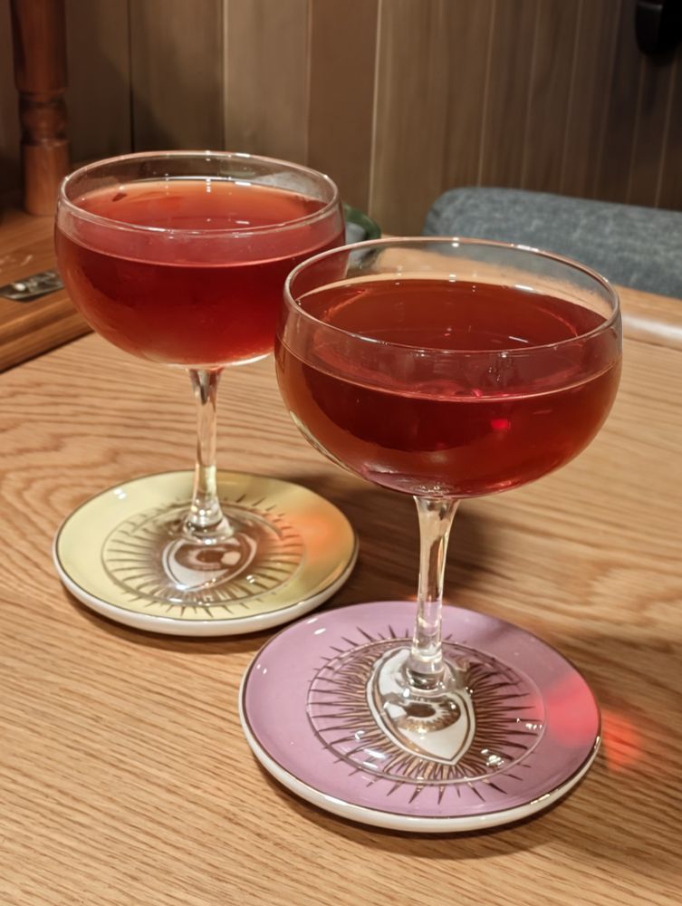 Two reddish brown cocktails in coupes 