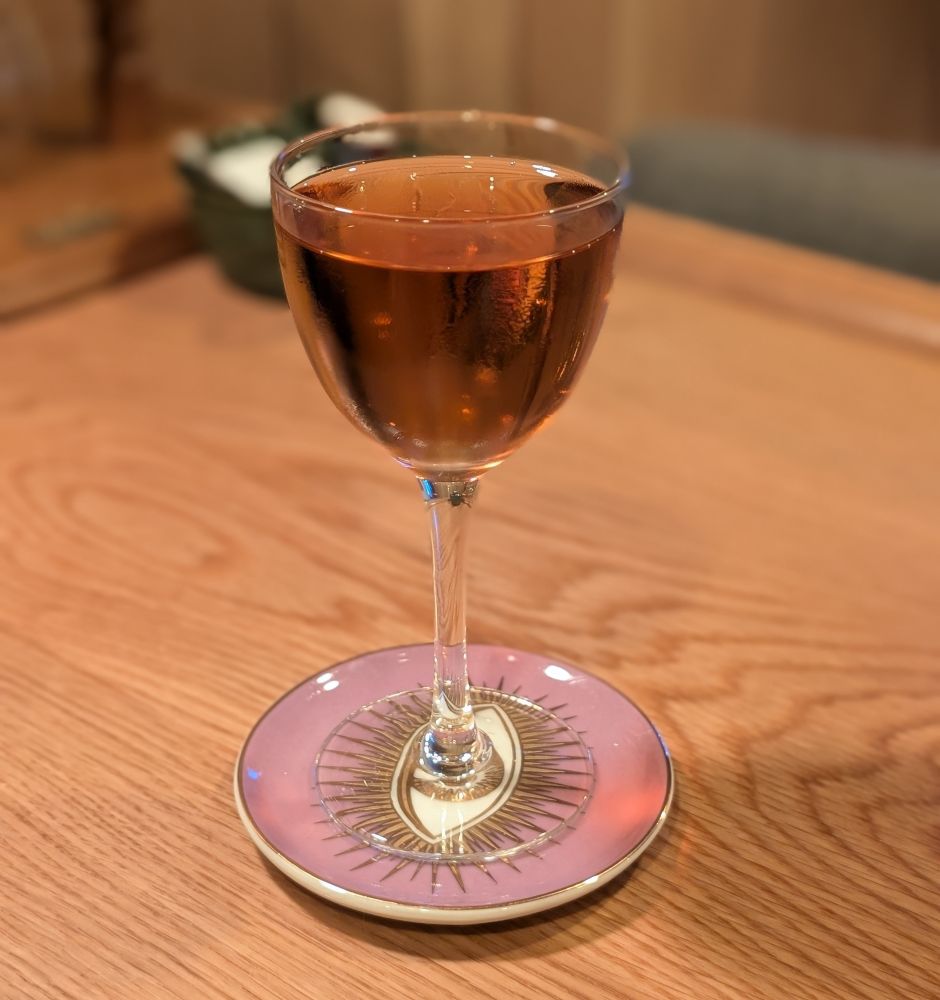 A brown cocktail in a Nick & Nora coupe
