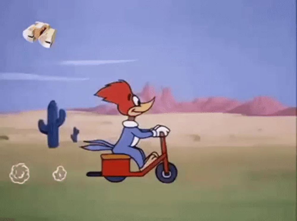 woody woodpecker is riding a scooter in the desert in a cartoon .