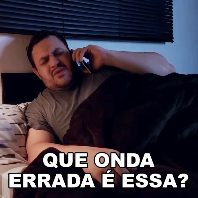 a man laying in bed talking on a cell phone with que onda errada e essa