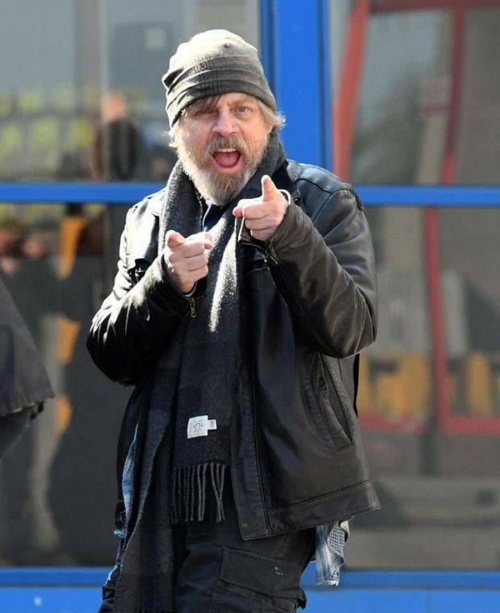 Mark Hamil fixe la caméra et fait 2 finger guns avec un grand sourire