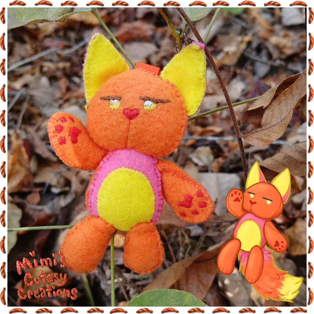 A small plush kitty cat with an orange head and arms. The front of their body and back of their ears are pink. They have a belly patch and inner ears that are yellow. embroidered serious yellow eyes with a red nose and red paw pads. They have a fluffy tail with a mixture of the three colors.