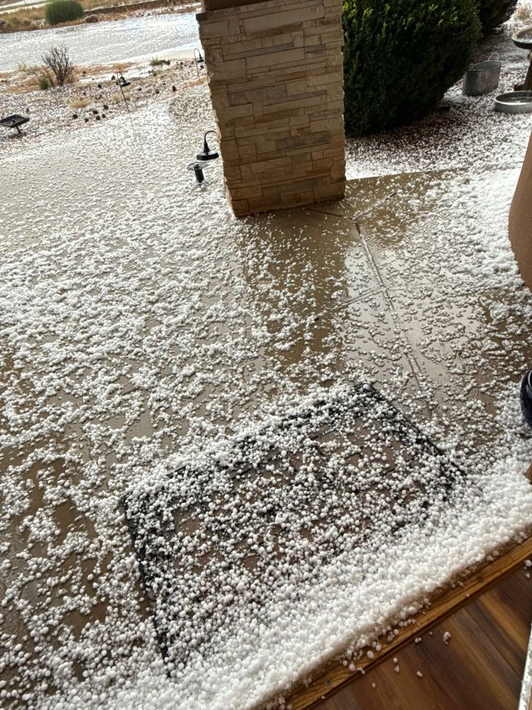 A shot of the front walk covered in hail somewhere between a pea and a dime.