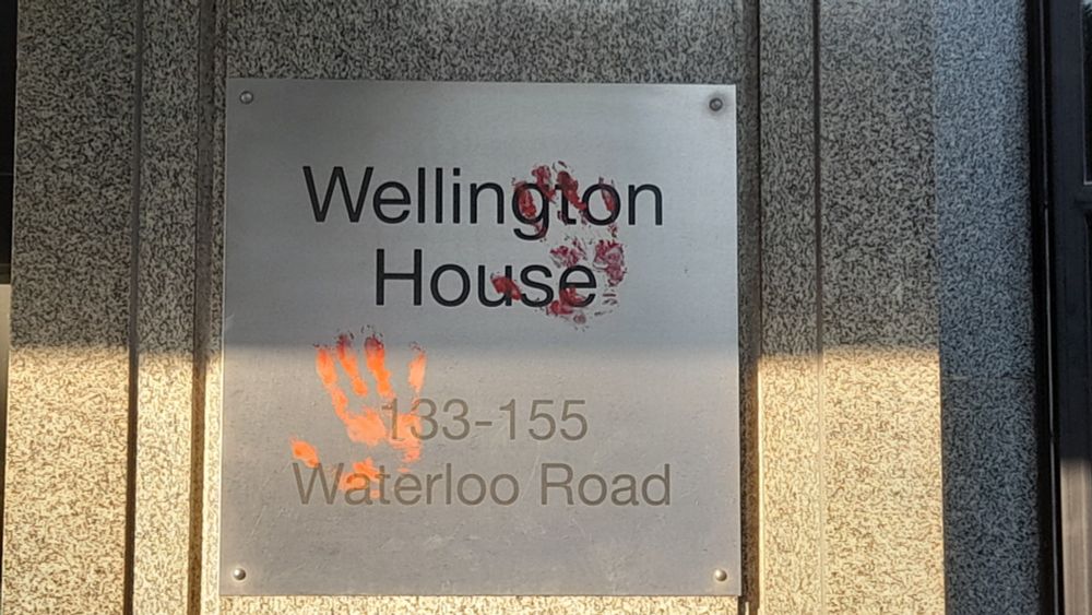 Sign stating "Wellington House, 135-155 Waterloo Road" covered in bloody handprints