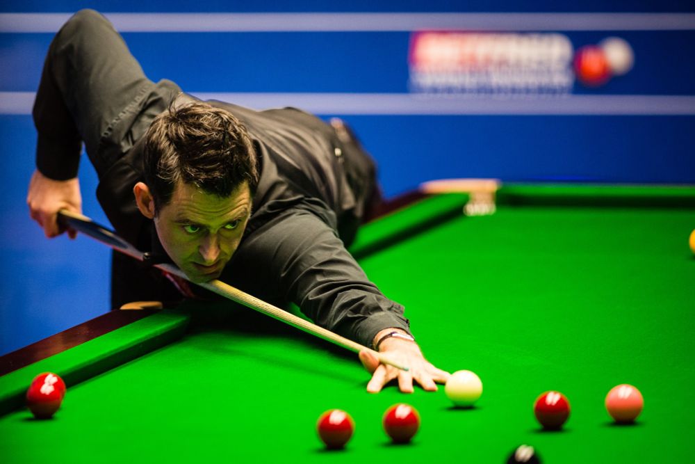 Ronnie O'Sullivan plays a shot on a snooker table.
