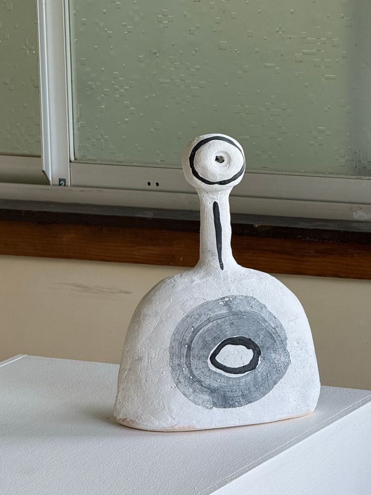 White washed Sculpture of abstract figure with one eye. 