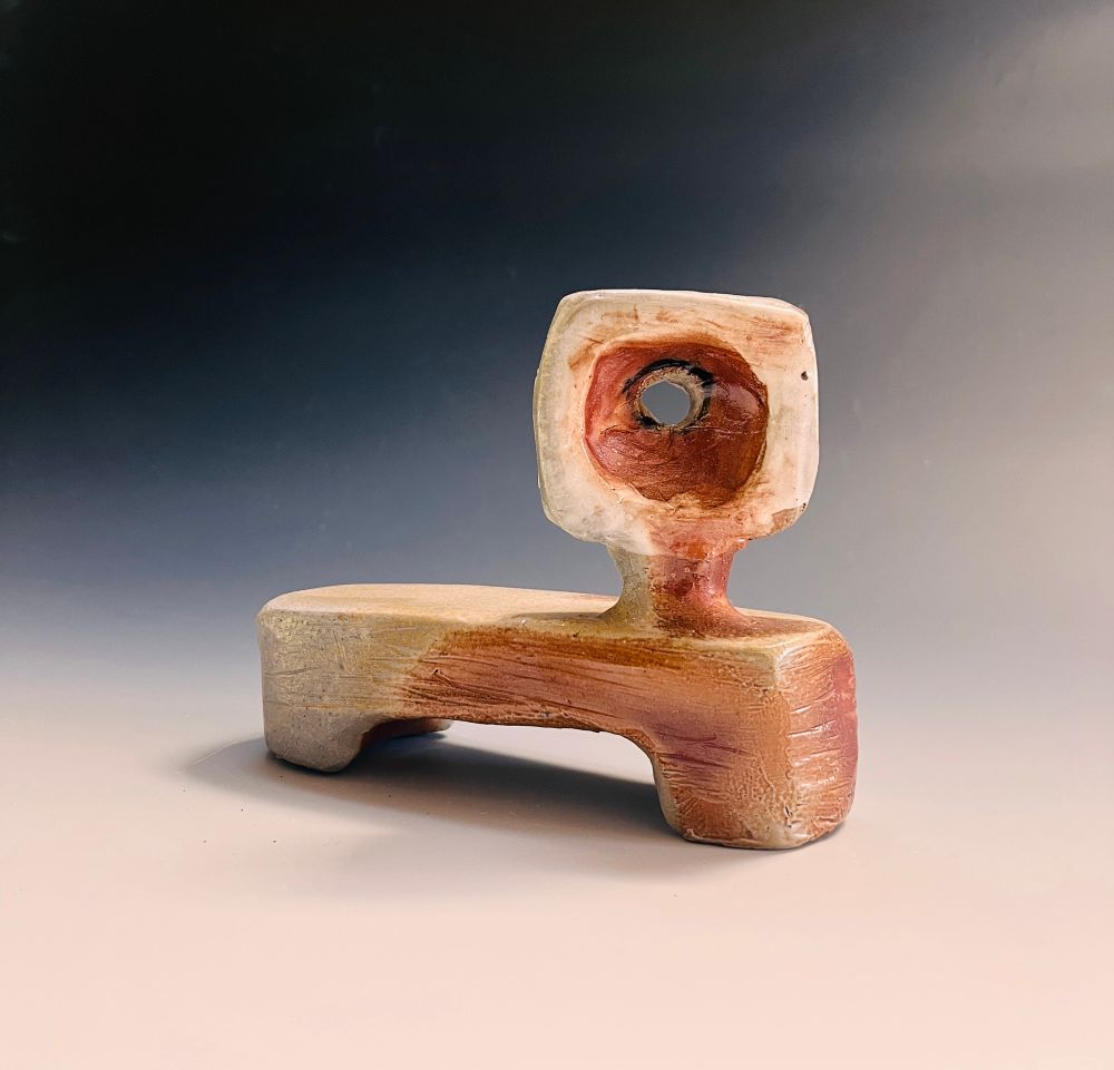 Ambiguous creature with long horizontal legs, no body, and a square head with a round hole in the middle.