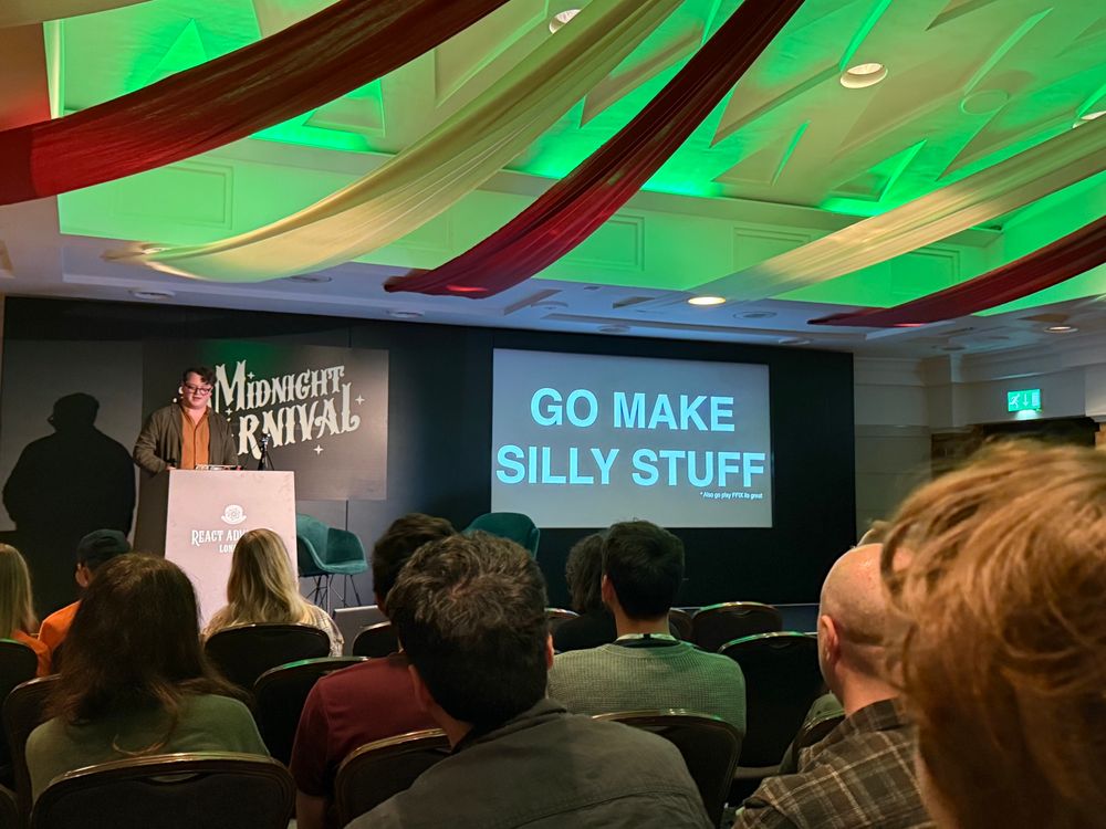 Joe on stage with a slide saying GO MAKE SILLY STUFF