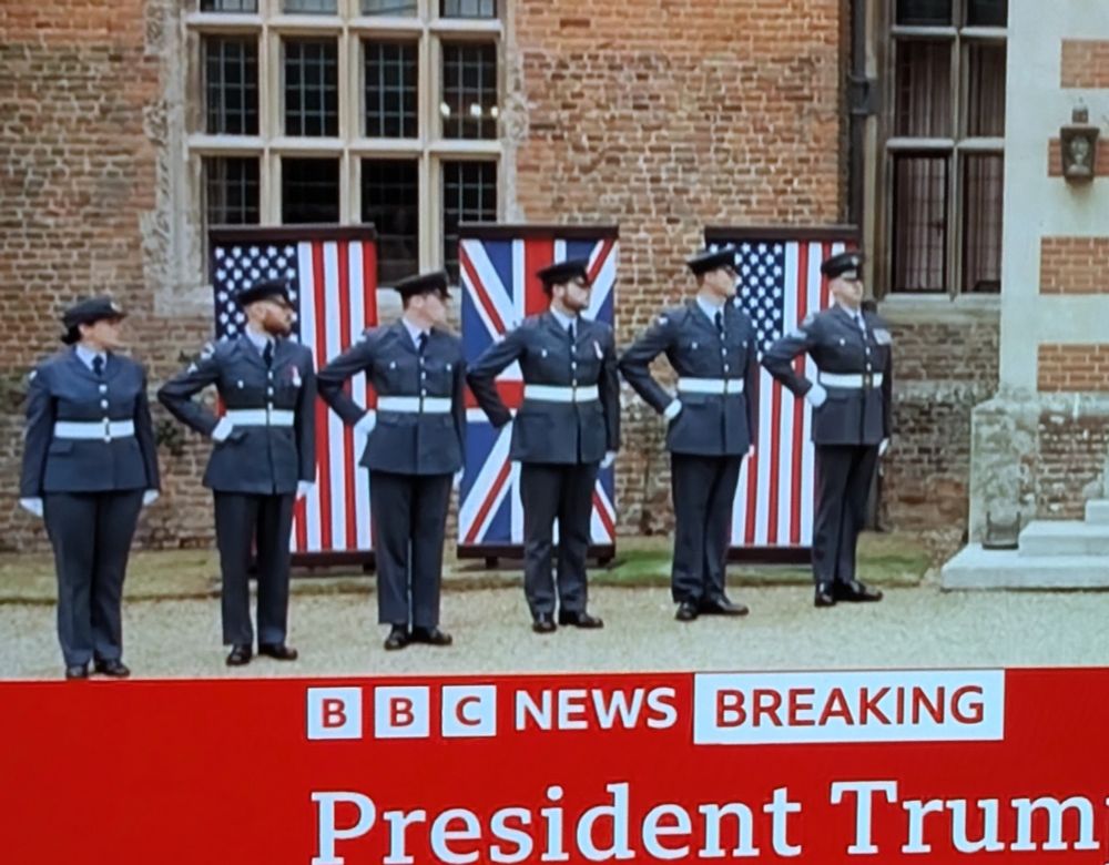 Members of the RAF stand as an honour guard outside Chequers, waiting for Trump, with one hand on their hip.