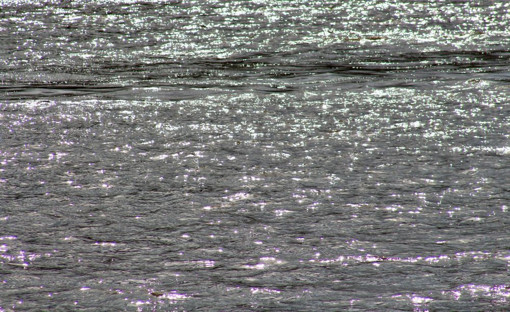 A dark band of light through a glitter path on the River Thames.