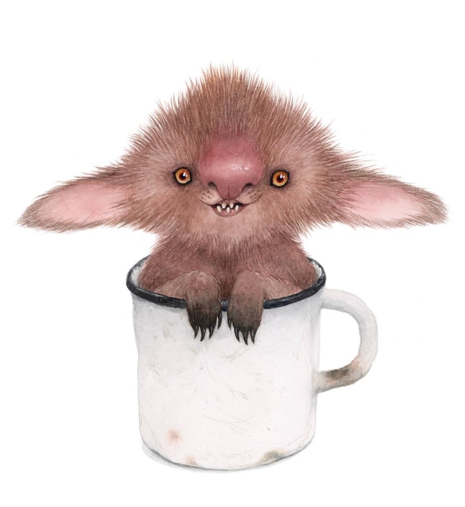 a cute brown hairy little creature sitting in a white mug