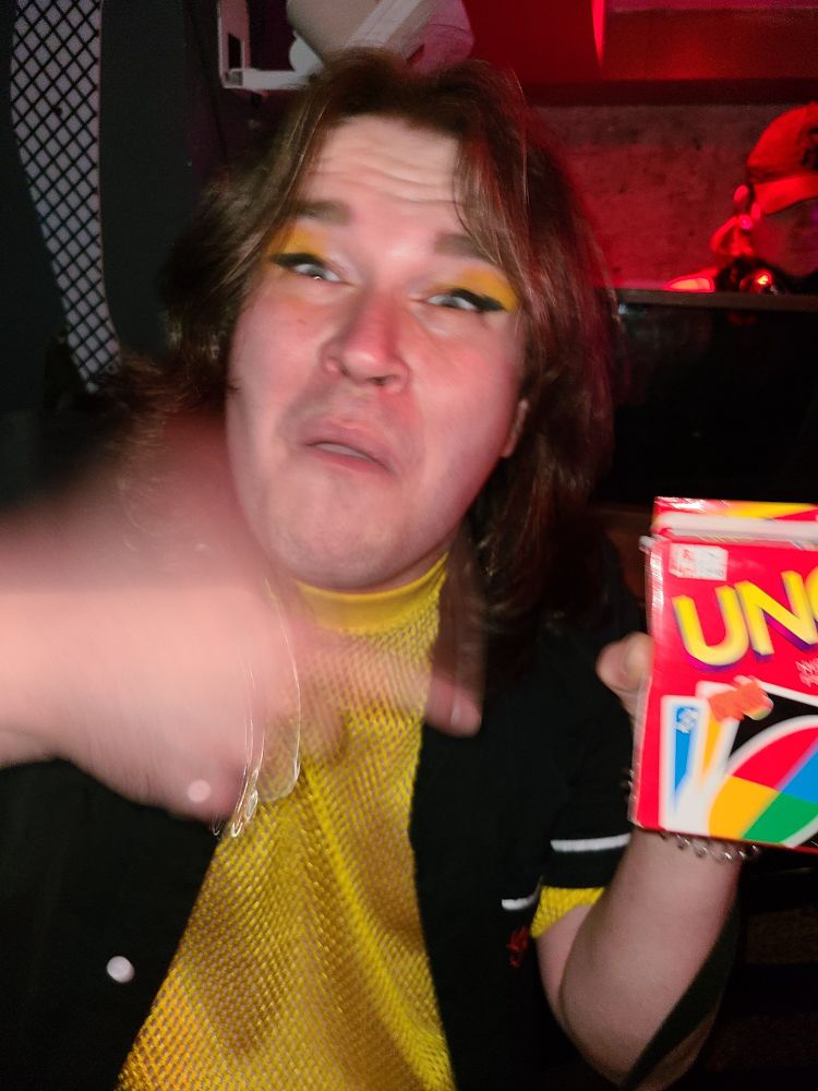 Woman gesturing enthusiastically to a pack of uno cards 