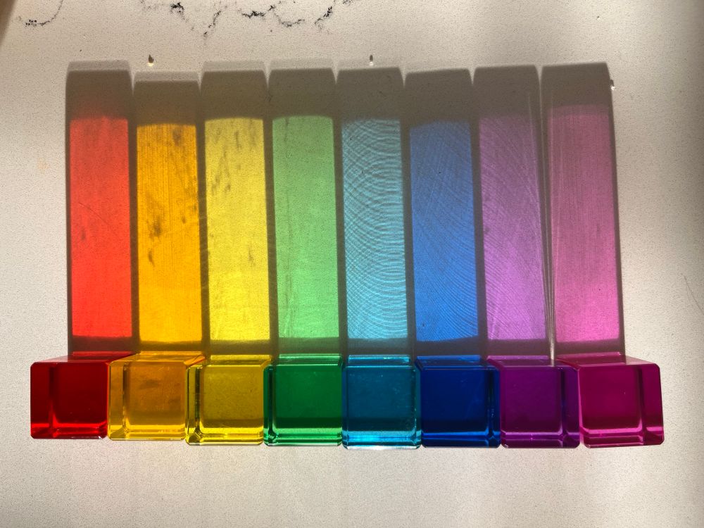 Colorful translucent plastic blocks casting rainbow shadows