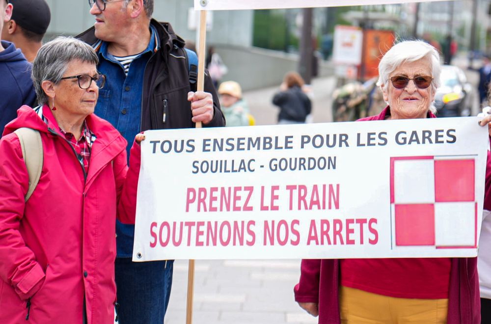 Deux manifestantes tiennent une banderole “Prenez le train, soutenons nos arrêts” pour les gares de Souillac et Gourdon. Leur message souligne l’importance du maintien des arrêts en zones rurales.