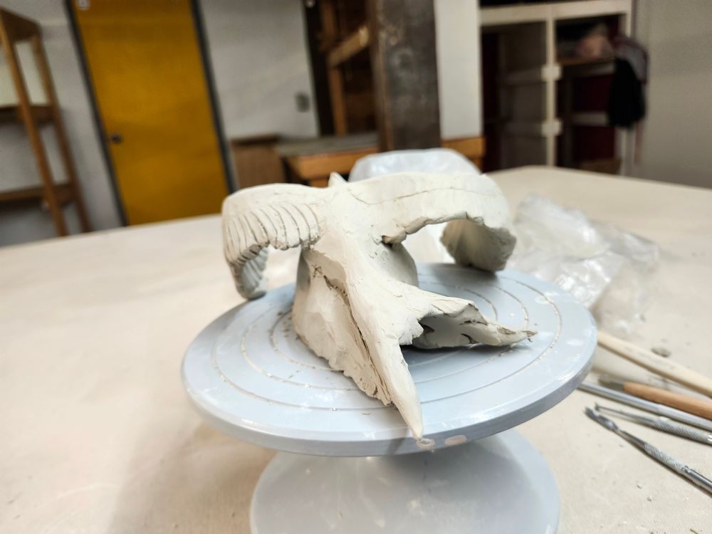 Day one as seen from the back, showing loose lines etched in (facing the wrong way) for the secondary  feathers on one side. The tail is a swallowtail shape but a bit arched and lopsided. 