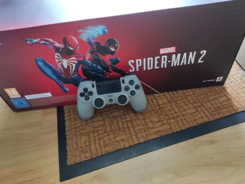 the boxed collectors edition next to a dualshock 4