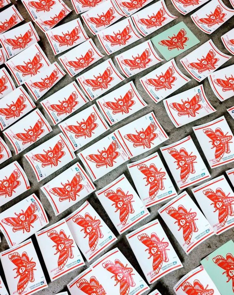 Drying 228 labels on the floor of my studio - hand screen printed moth-skull bugs in red ink