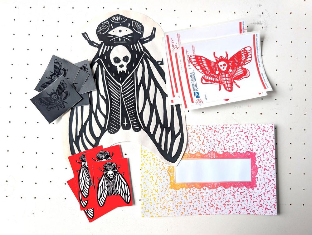The contents of a typical sticker pack: 3 different stickers by west coast graffiti & wheatpaste artist DEBUG - hand screen printed label 228s with red moth, black-on-black limited edition moth vinyl stickers, red eggshell security stickers. 

Each pack usually contains fun stuff like one of these hand screen printed "big bugs" for wheatpasting and a colorful printed enveloped.

Photographed on my printmaking vacuum table from above