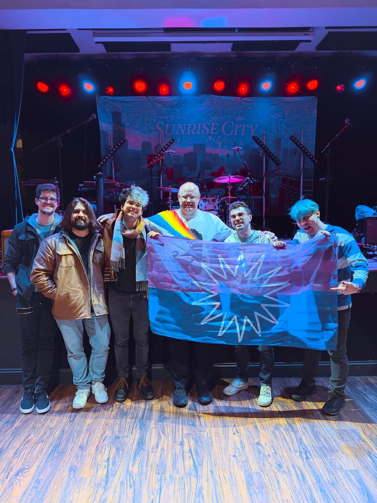 Group photo with Sub-Radio band members during VIP session. I’m in the middle, and a Sunrise City flag that I brought is being held by Matt, Adam, and Mike