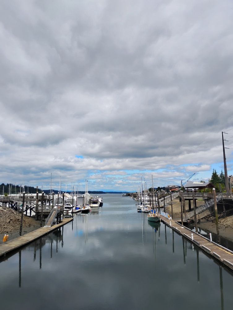 Clouds over Budd Inlet.

Bly sky on the horizon.

The harbor is lined by two docks, boats and the downtown marina at low tide.
