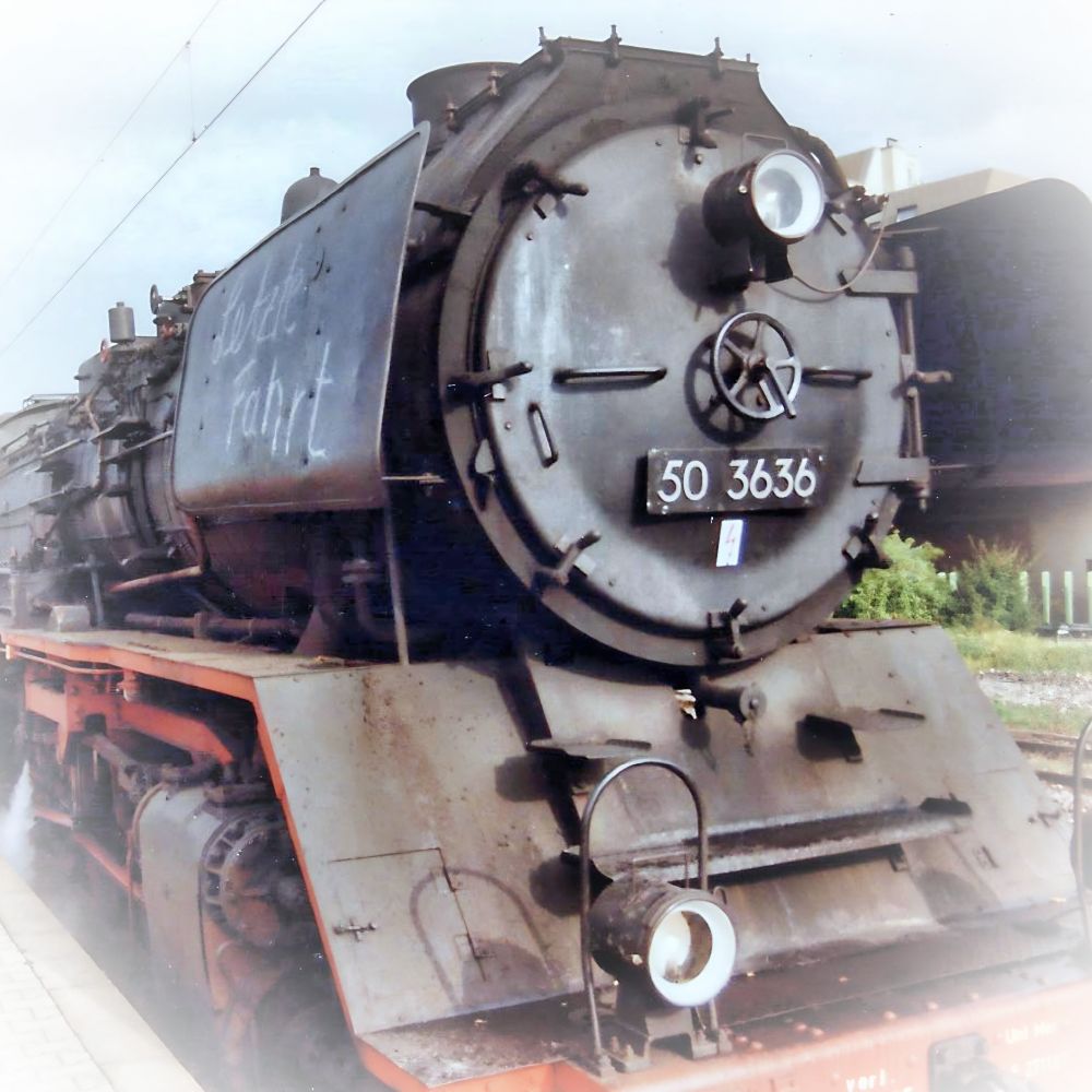 Dieses Bild zeigt die historische Dampflokomotive "Feuriger Elias" in einer Frontalansicht. Sie ist eine große, schwarze Dampflok mit einem zylindrischen Kessel und einer charakteristischen runden Rauchkammertür. Sie wird noch heute als Touristenattraktion eingesetzt.