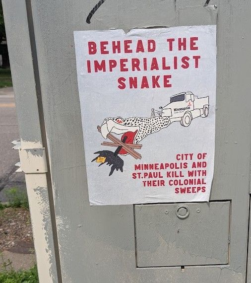 A small poster wheat pasted to the side of a public utility box. It shows a Minneapolis public works truck with a snake attached to the front like a snow plow.  The test on the poster reads, "Behead the imperialist snake. City of Minneapolis and St. Paul kill with their colonial sweeps." 
