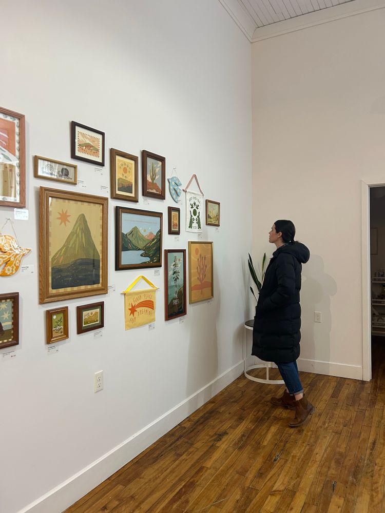 Emma Harrison admiring a gallery wall at the First Friday Art Crawl