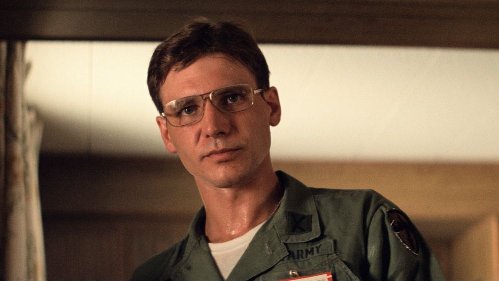 A very young looking Harrison Ford wearing glasses & a US military uniform.