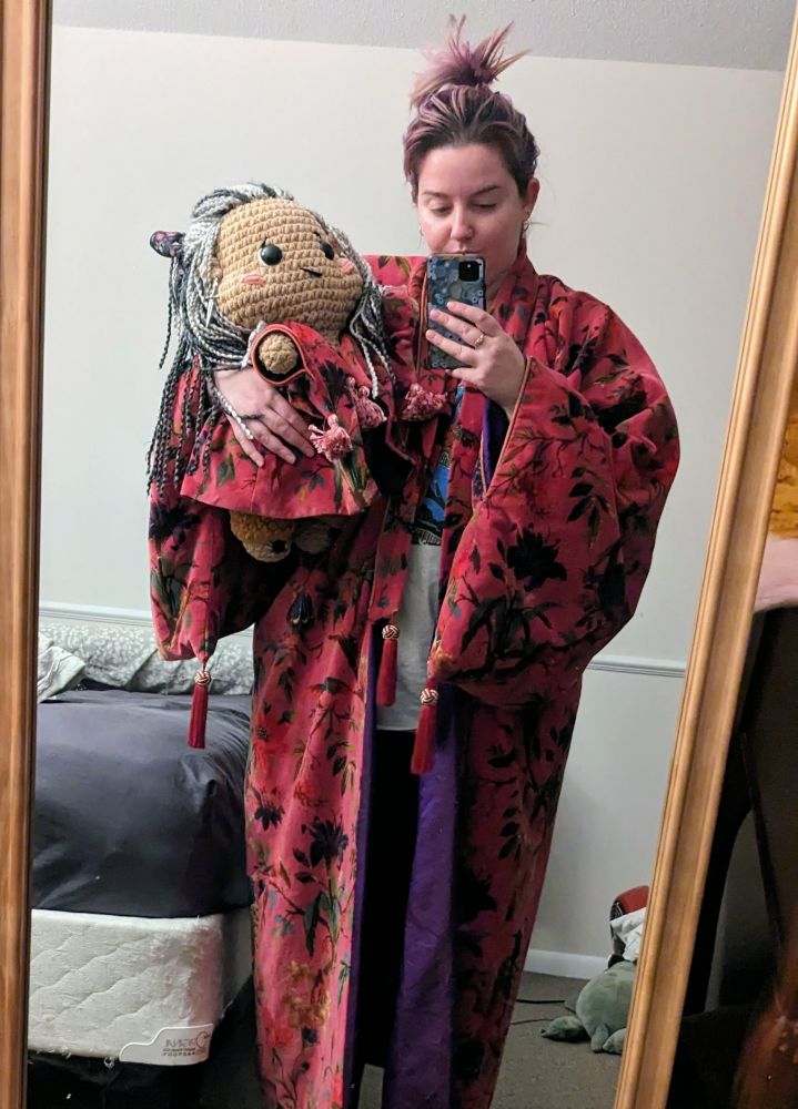 A lady in a pink robe holding a doll in a pink robe 