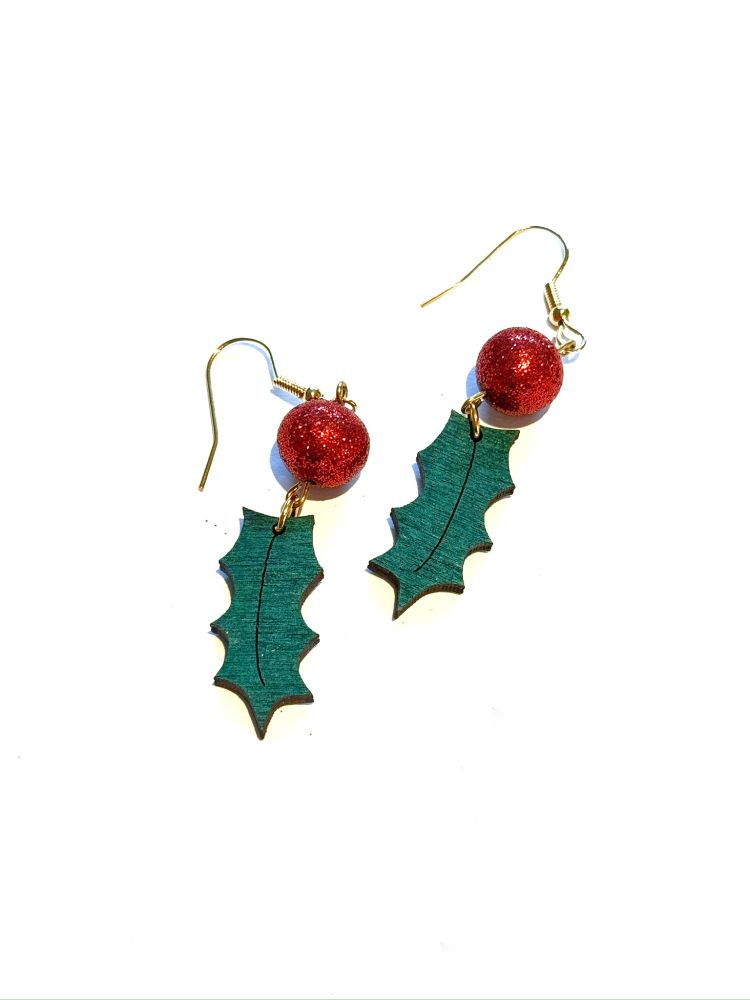Holly earrings where the berry is sparkly red polymer clay and the leaf is painted wood.
