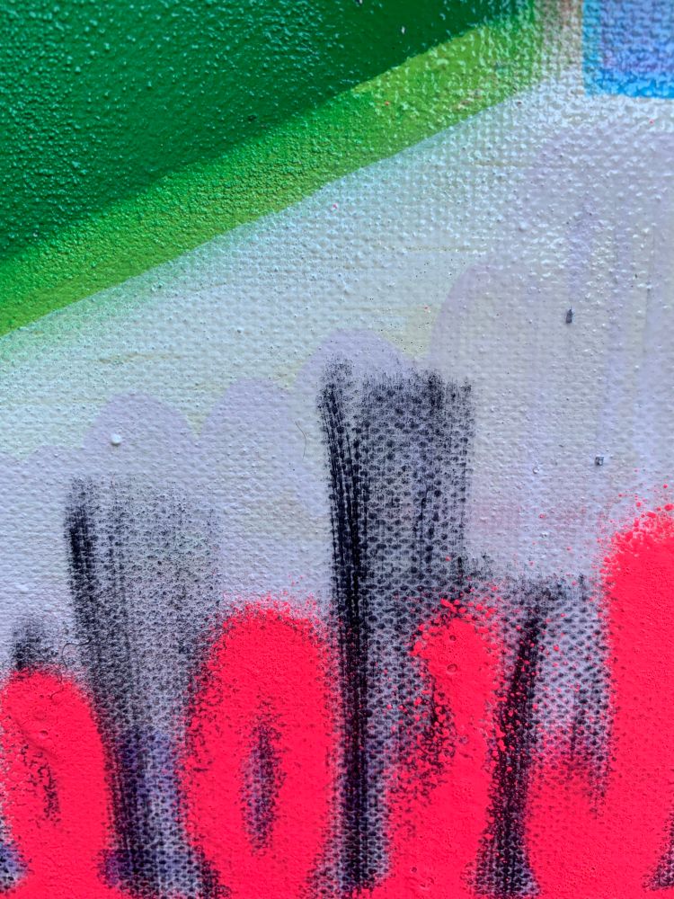 Green Lego building brick stencilled onto a canvas with pink , blue and yellow abstract marks - A close up 