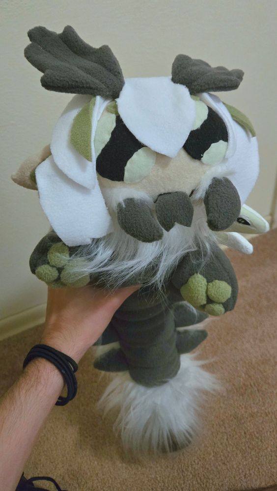 A photograph of a detailed plush, with faux fur details, toe-beans, and white hair.