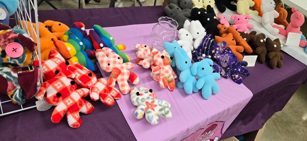 A photograph of various small patterned plushies, including flowers, picnic blankets, and stars.