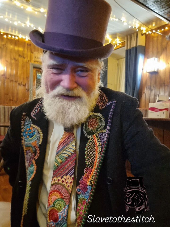 Me wearing my own colourfully hand embroidered tie and black wool coat with stitching on the labels. Topped off with my new purple top hat.