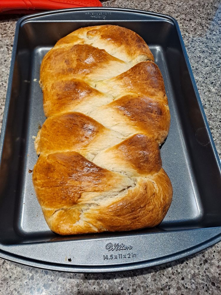 A baking tray with a fresly baked loaf of Hefezopf. 