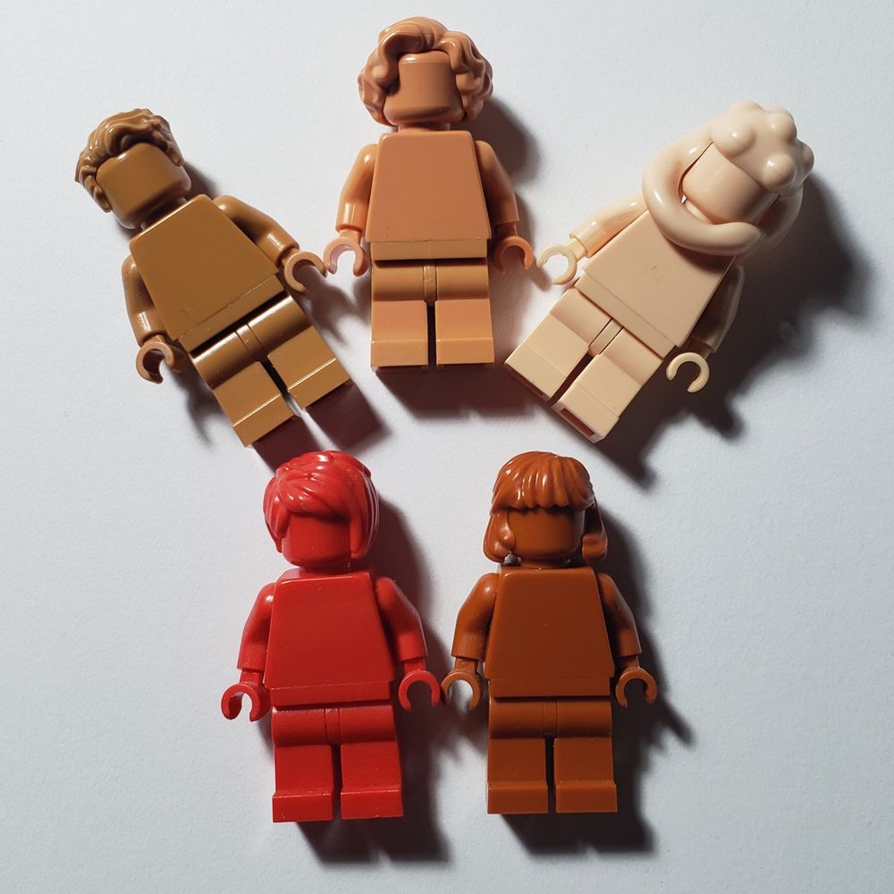 5 monochrome Lego minifigures, Medium Nougat, Nougat, Light Nougat, Red and Dark Orange. The Nougat legs and torso don't match.