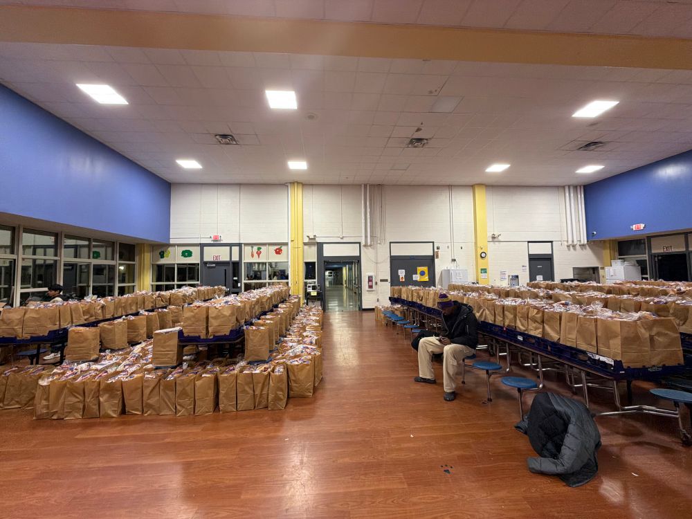 Photo of the cafeteria portion of the Lakewood Gym, showing hundreds of packed bags of food ready for distribution to schools 