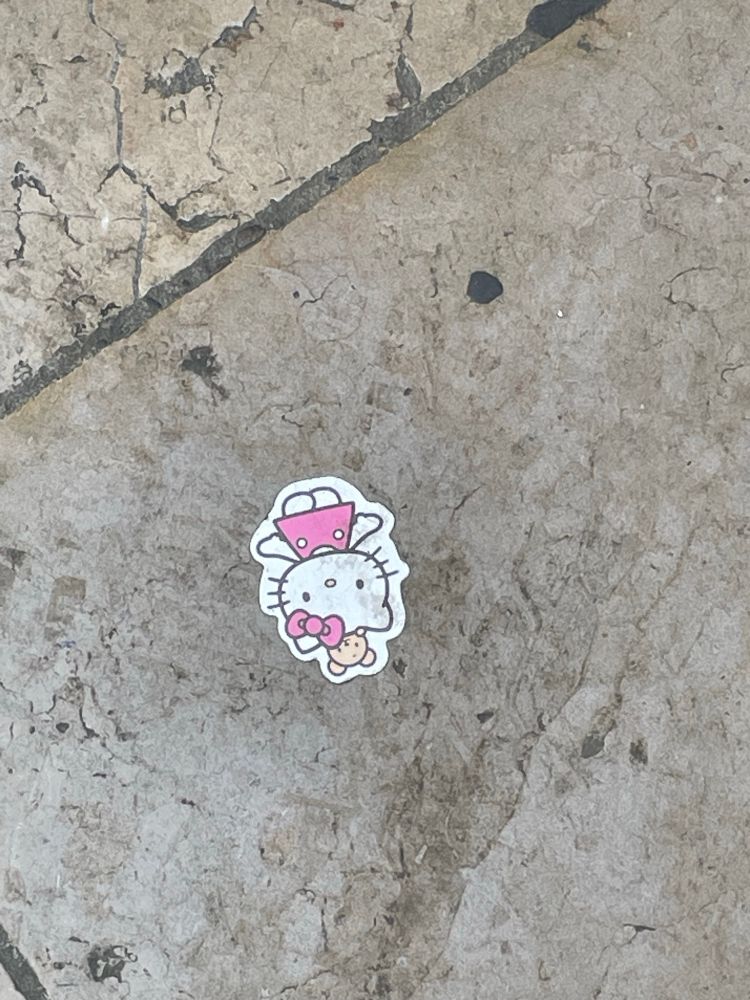 Sticker Hello Kitty collé sur le sol tout sale de la rue Sainte Catherine.
