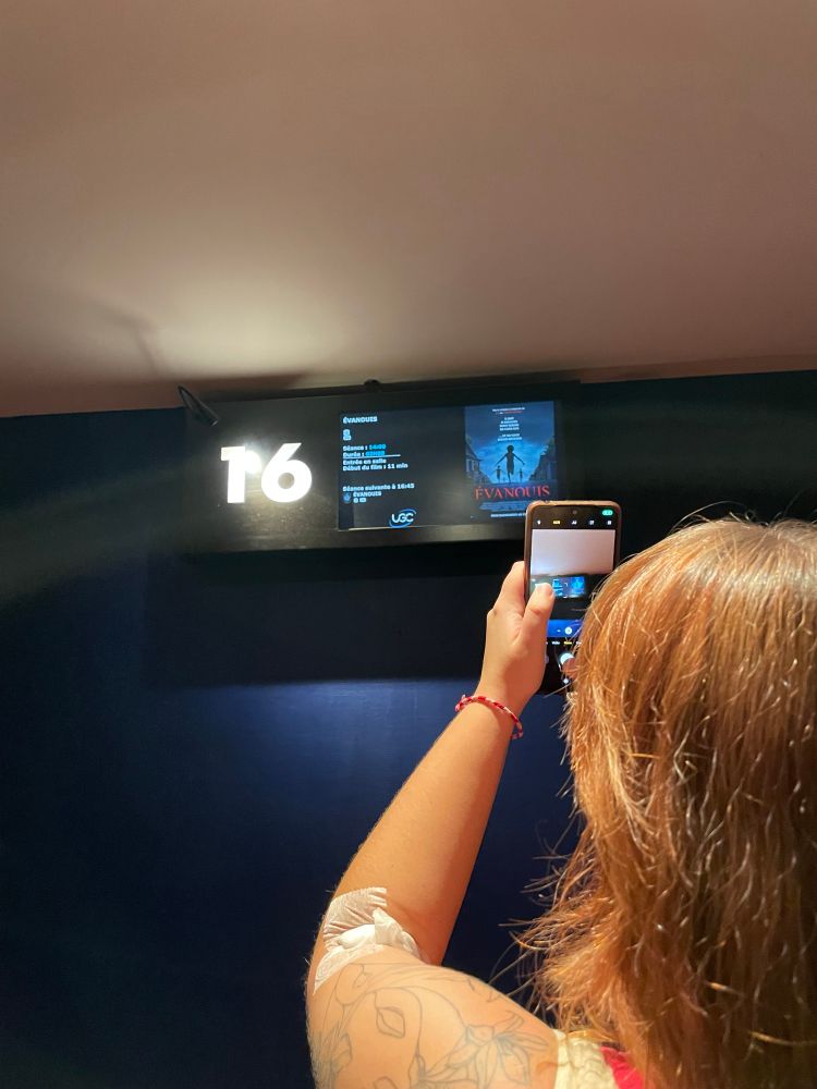 Hades qui prend en photo le panneau de la salle 16 du cinéma avec le film Évanouis (Weapons).