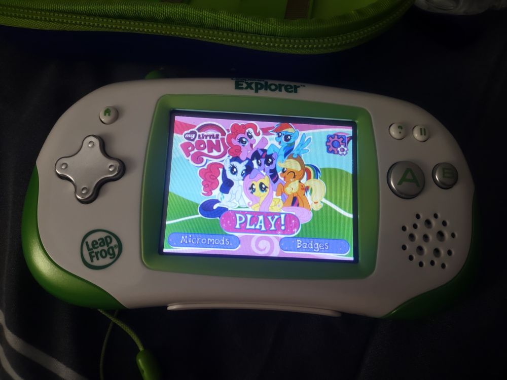 Photo of a Leapster Explorer game console showing a My Little Pony game ready to play.