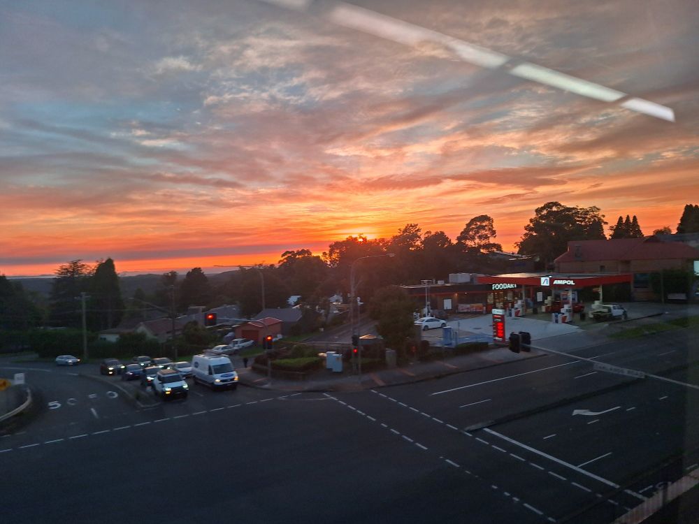 Vivid pink sunrise peaking from behind the Hazelbrook petrol station 