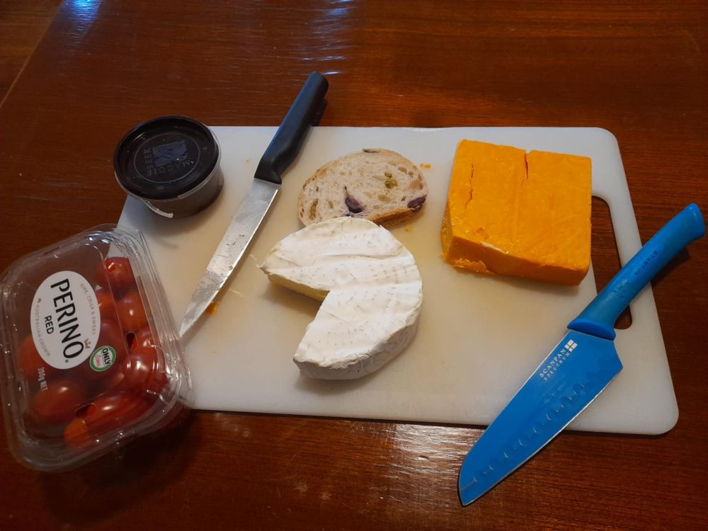 Platter with two cheeses, tomatoes, quince paste and olive bread