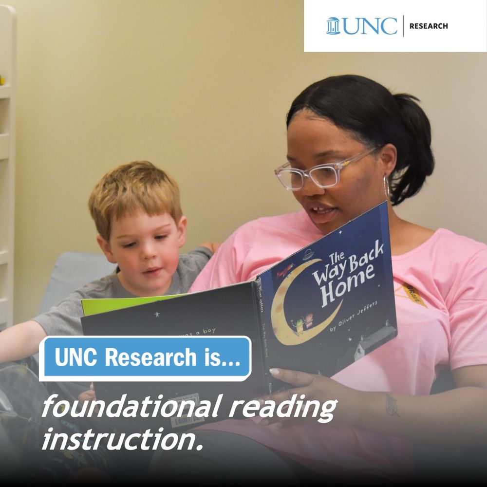 A female teacher sits with a pre-K aged boy and reads a children's book. 