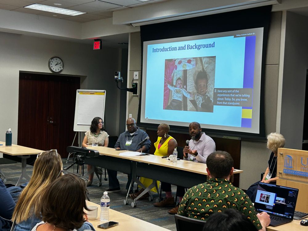 A panel of family advocates sits at a table in front of an audience.