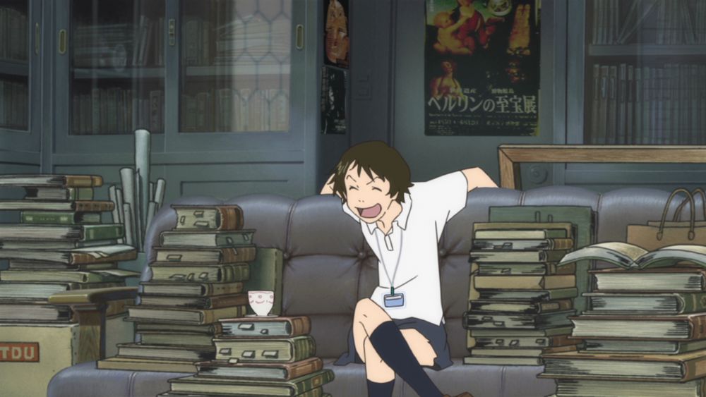 Makoto sitting on a couch alongside a ton of books with a teacup set on one of them, she's also laughing in this one
