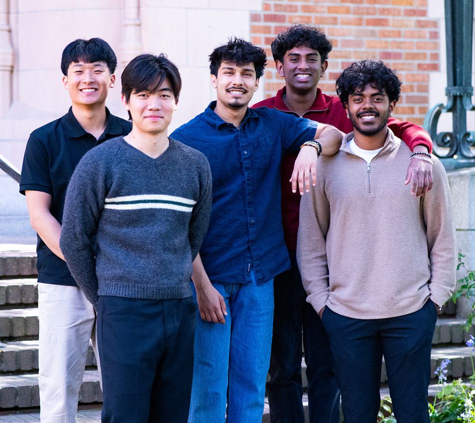 Five Informatics students are standing together, smiling. 
